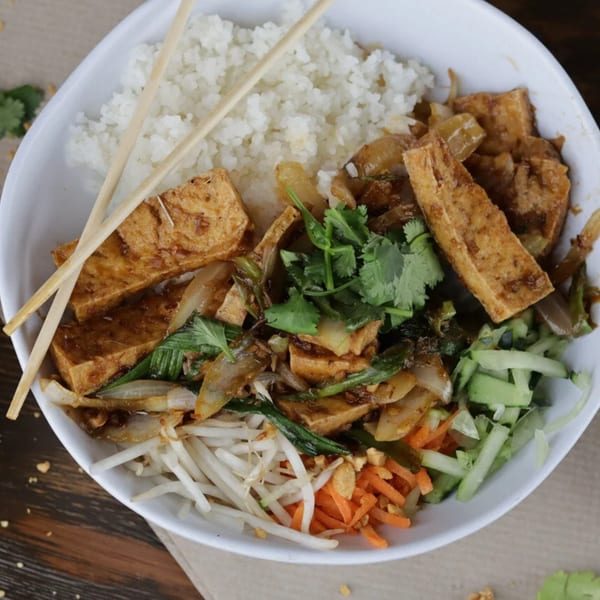 A Vietnamese rice bowl with tofu, vegetables, and chopsticks, from Pho Tre Bien.